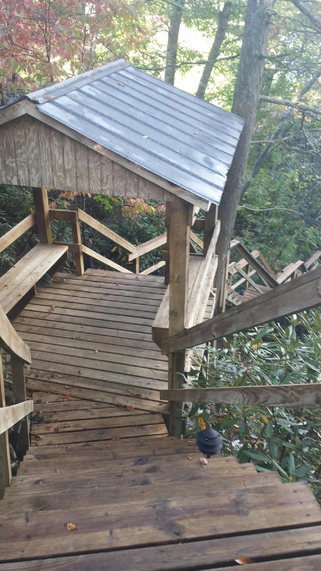 Metal roofed shelter over wooden steps on a wooded walkway — Skylight Repair & Installation work by our crew in South Salem